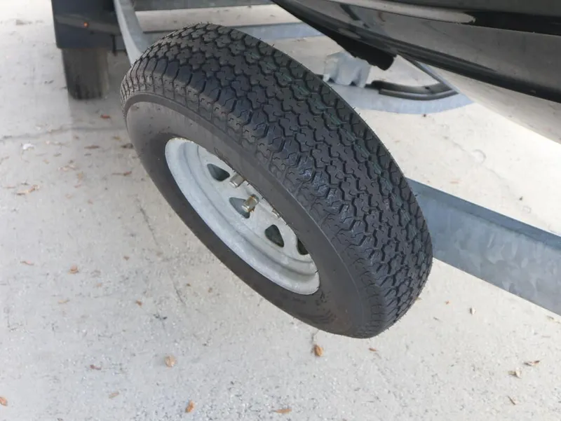 Slide: The Image of Trailer tire for 2022 Yamaha Boats 255XD on sandy ground. - 9