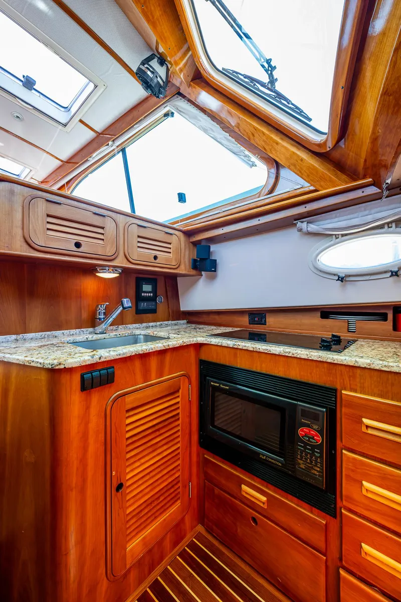 Slide: The Image of 2006 Hinckley Talaria 44 MY yacht kitchen with wooden cabinetry and skylight. - 19