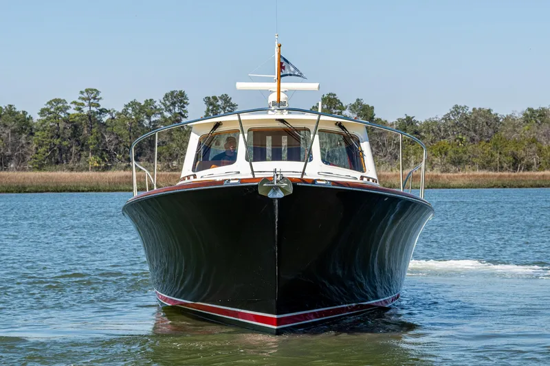 Slide: The Image of 2006 Hinckley Talaria 44 MY yacht cruising on a calm river with forested background. - 2