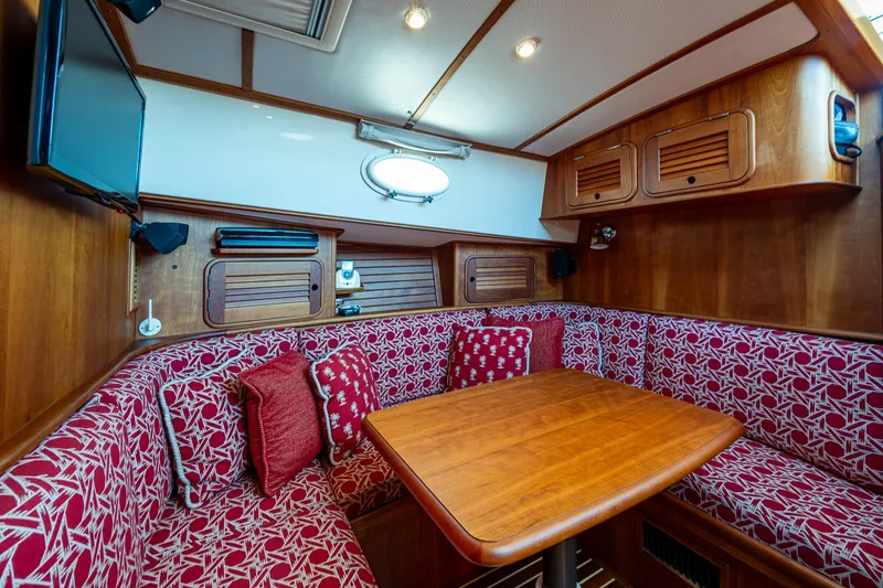 Slide: The Image of Interior of 2006 Hinckley Talaria 44 MY with red patterned seating and wooden table. - 23