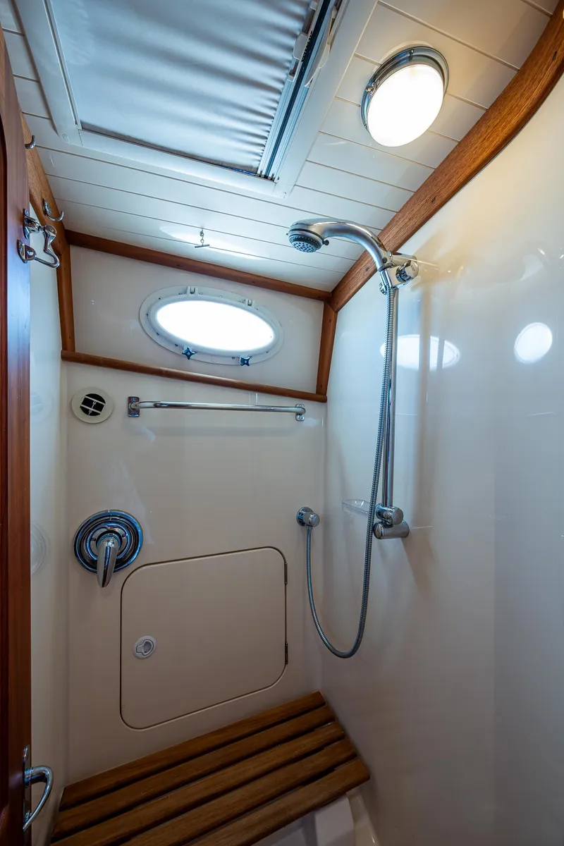 Slide: The Image of 2006 Hinckley Talaria 44 MY yacht shower with wooden bench and porthole window. - 29