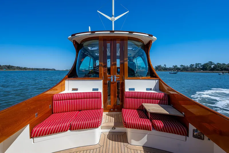 Slide: The Image of Luxurious 2006 Hinckley Talaria 44 MY cabin with red-striped bedding and elegant wood paneling. - 8