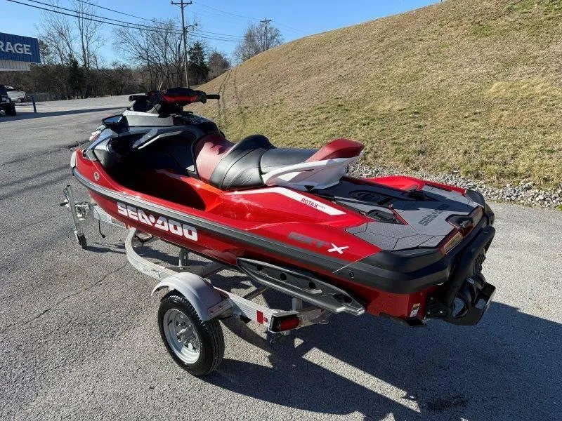 Slide: The Image of 2024 Sea-Doo RXT-X 325 jet ski on trailer, parked outdoors. - 3