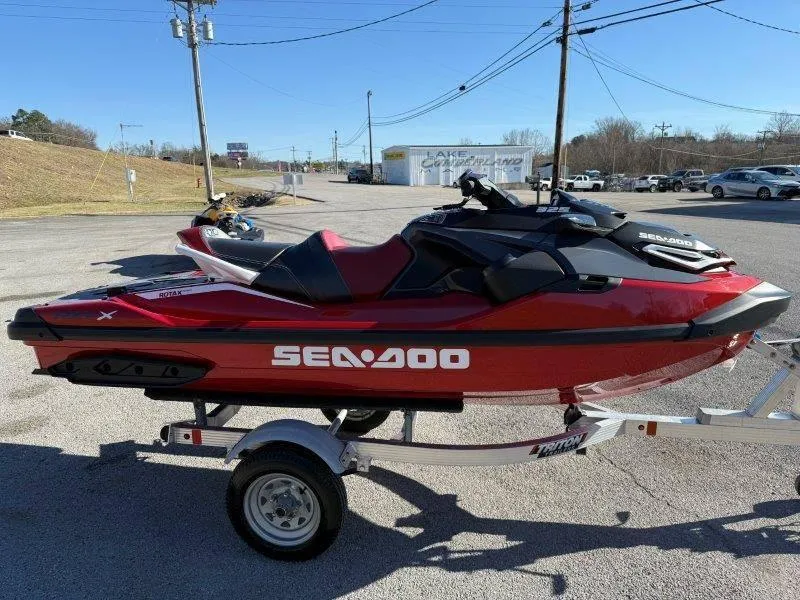 Slide: The Image of 2024 Sea-Doo RXT-X 325 jet ski on trailer, parked outdoors. - 4