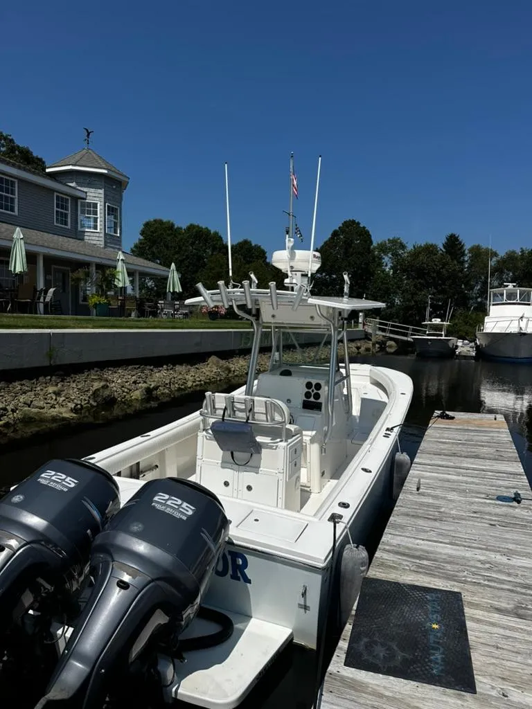 Slide: The Image of 2005 Regulator 26 FS boat docked by a waterfront building under clear blue skies. - 3