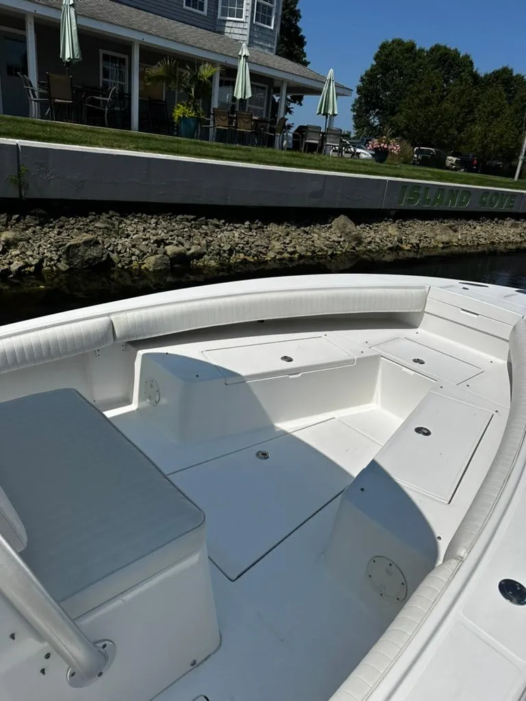 Slide: The Image of 2005 Regulator 26 FS boat, white deck, docked near a waterfront property. - 5