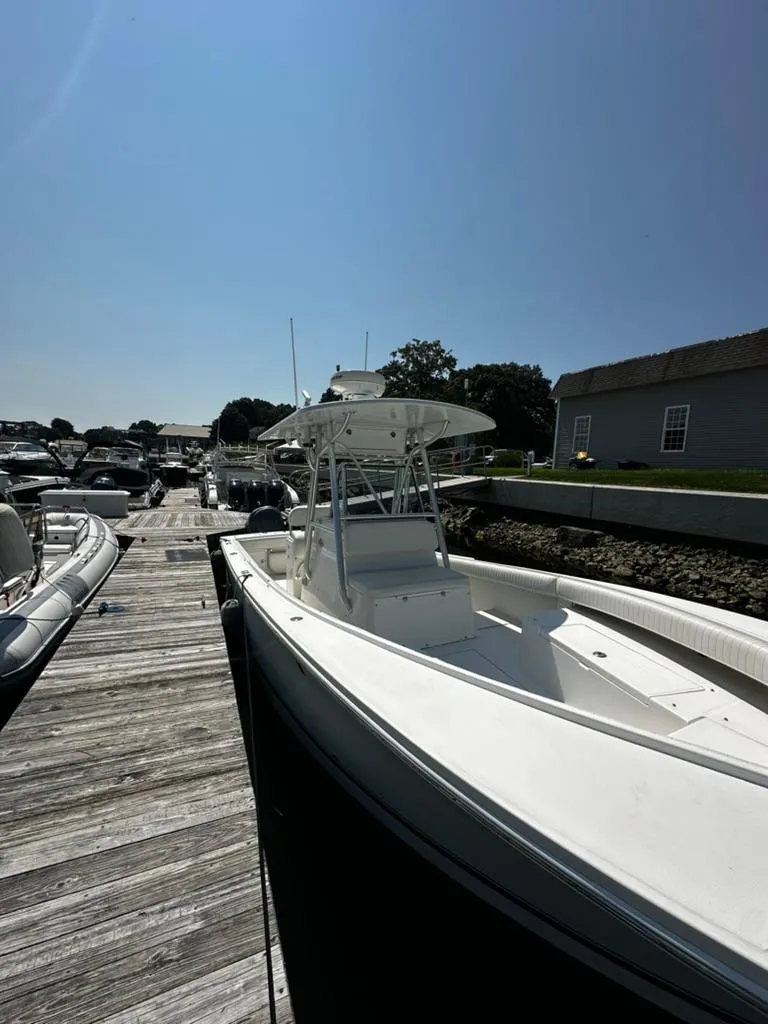Slide: The Image of 2005 Regulator 26 FS boat docked at a marina under clear blue sky. - 7