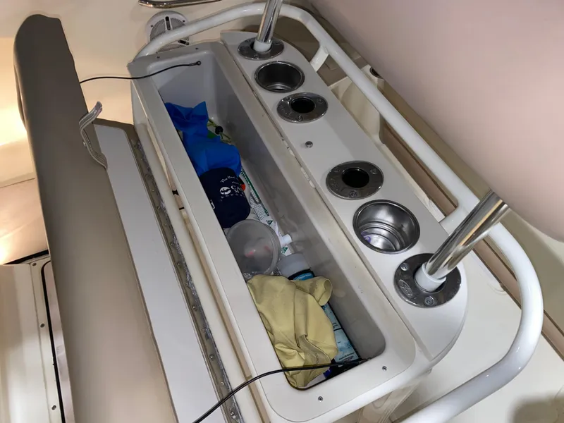 Slide: The Image of 2011 Scout 222 Sportfish boat storage compartment with cup holders and gear. - 22