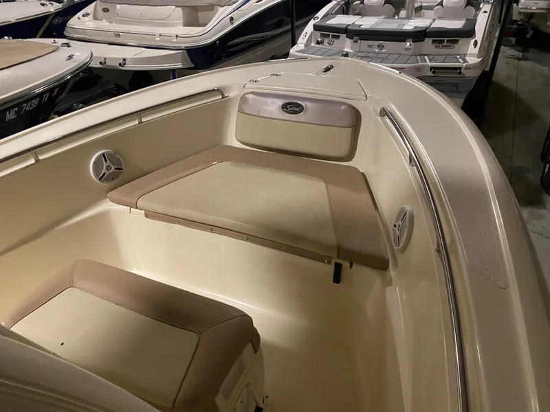 Slide: The Image of 2011 Scout 222 Sportfish boat interior with beige seating and storage compartments. - 48