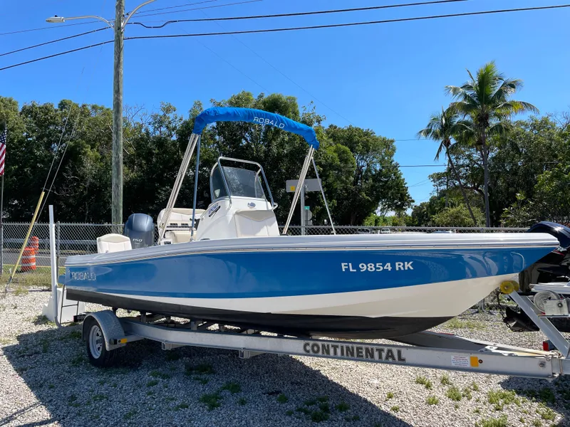 Slide: The Image of 2017 Robalo 206 Cayman boat on trailer, blue hull, parked outdoors. - 3