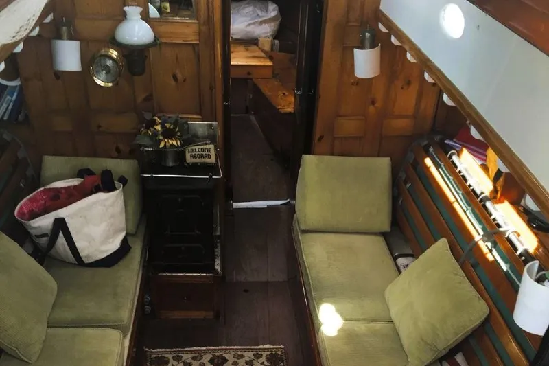 Slide: The Image of Interior of a 1952 Concordia Yawl with cozy seating and wooden paneling. - 3
