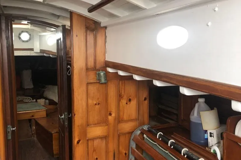 Slide: The Image of Interior of a 1952 Concordia Yawl sailboat with wooden paneling and nautical decor. - 4