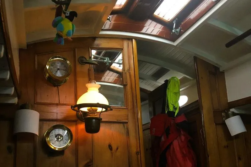Slide: The Image of Interior of 1952 Concordia Yawl with wooden paneling, nautical instruments, and hanging lamp. - 5