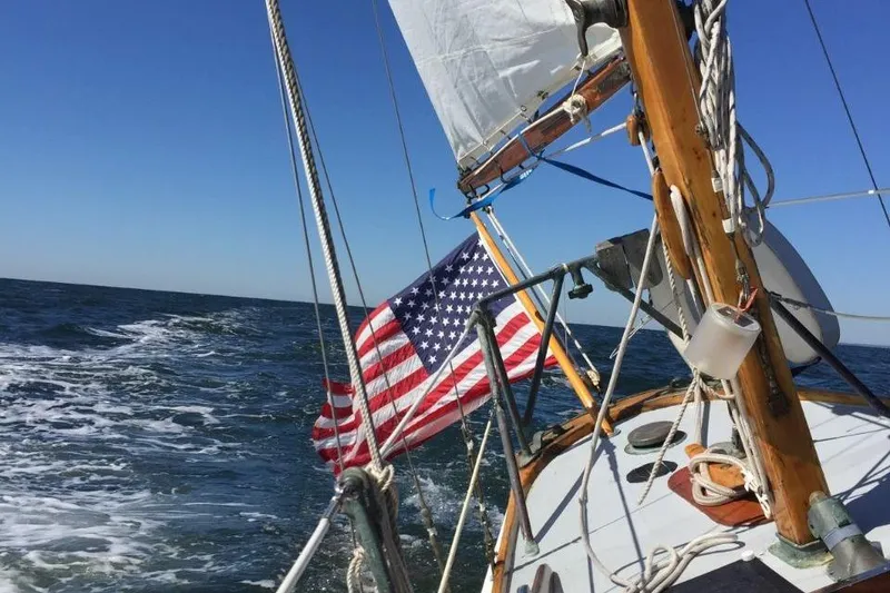 Slide: The Image of 1952 Concordia Yawl sailing with American flag on open sea. - 6