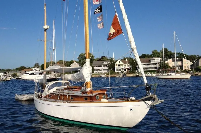 Slide: The Image of 1952 Concordia Yawl sailboat anchored in a scenic harbor with clear blue skies. - 9