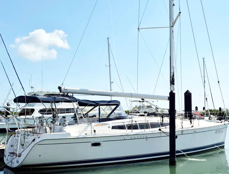 The Image of 2012 Hunter 50 Aft Cockpit sailboat docked in marina under clear blue sky. - 0