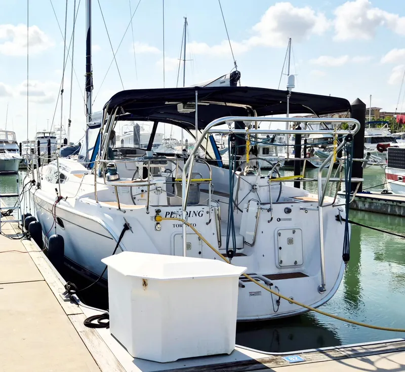 Slide: The Image of 2012 Hunter 50 Aft Cockpit yacht docked at marina under sunny skies. - 1