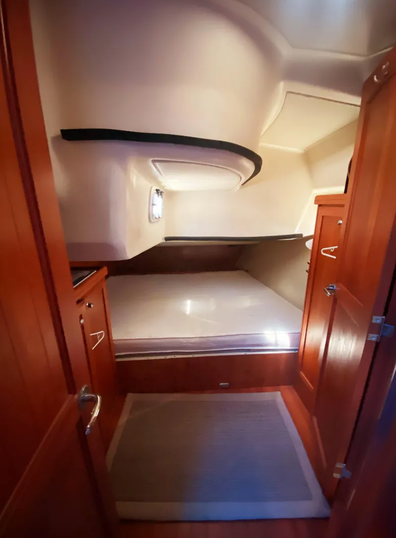 Slide: The Image of 2012 Hunter 50 Aft Cockpit cabin interior with wooden finish and cozy bed. - 19