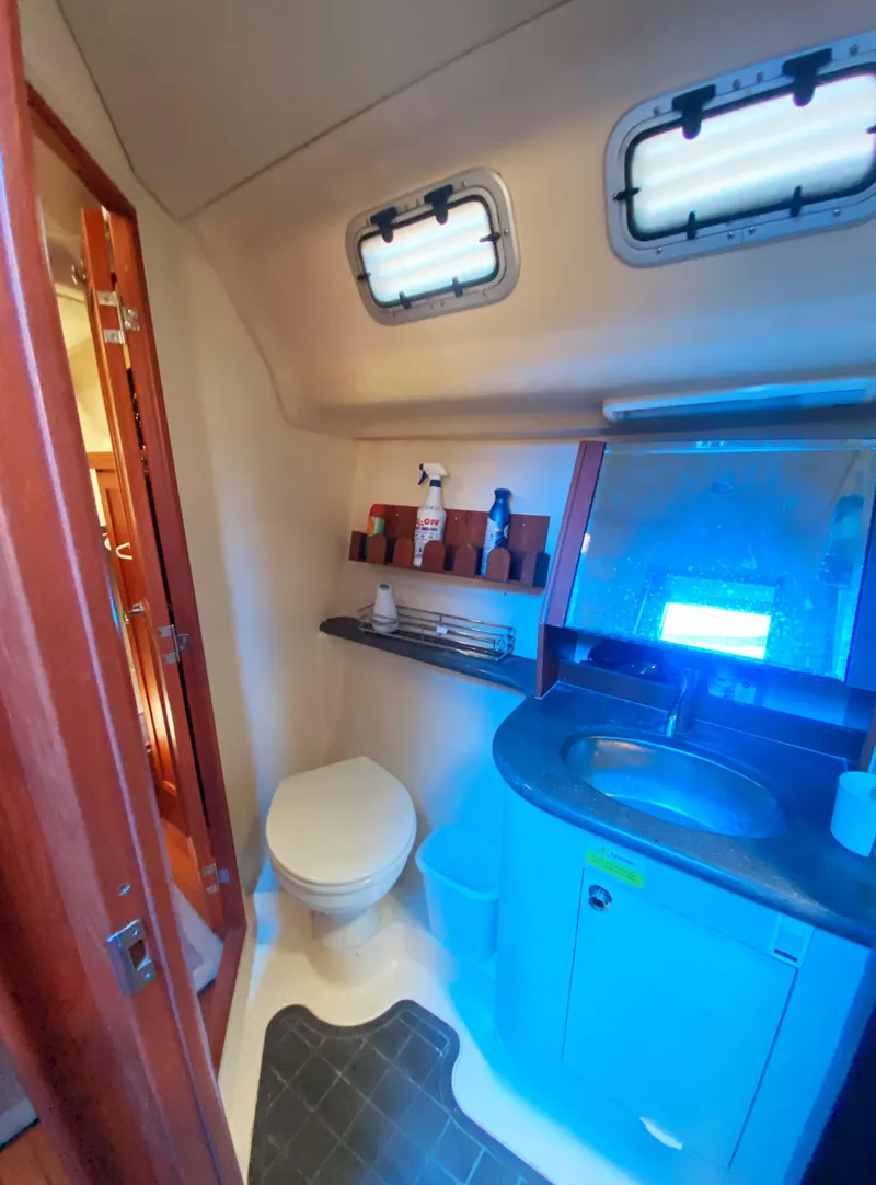 Slide: The Image of 2012 Hunter 50 Aft Cockpit bathroom with sink, toilet, and storage shelves. - 21