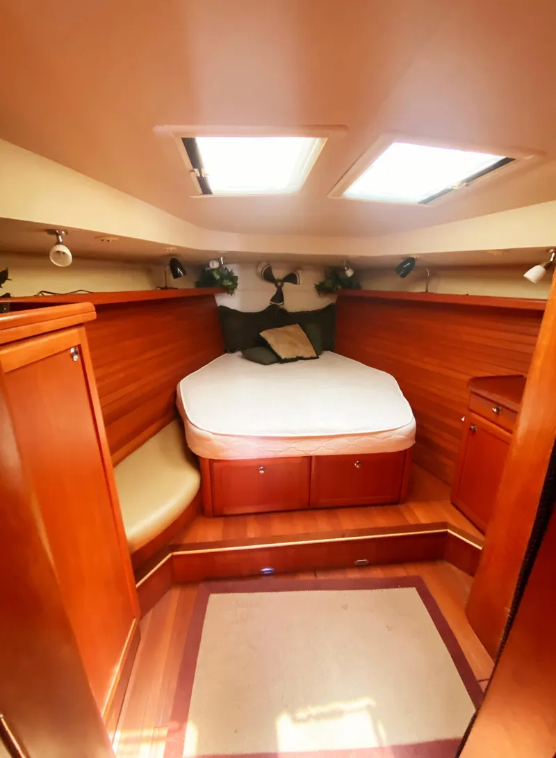 Slide: The Image of 2012 Hunter 50 Aft Cockpit interior cabin with bed, wooden finish, and overhead skylights. - 25