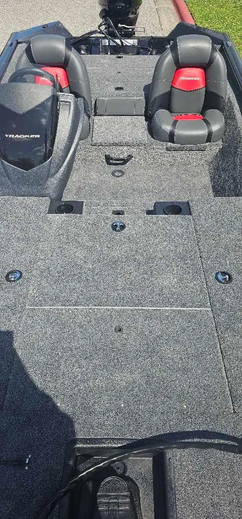 Slide: The Image of 2025 Tracker Pro Team 175 boat interior with gray carpet and red-accented seats. - 4
