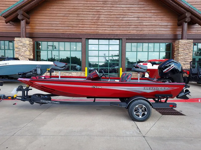 The Image of 2025 Ranger RT178 red fishing boat parked outside a wooden building. - 0