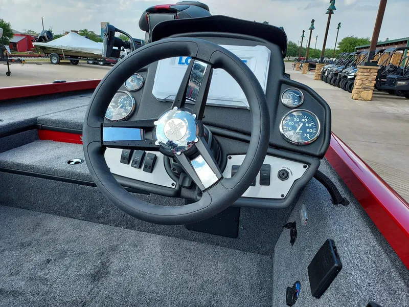 Slide: The Image of 2025 Ranger RT178 boat dashboard with steering wheel and gauges, outdoor setting. - 2