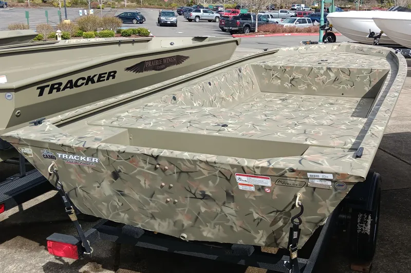 Slide: The Image of 2025 Tracker Grizzly 1648 Jon boat with camouflage design on a trailer. - 2