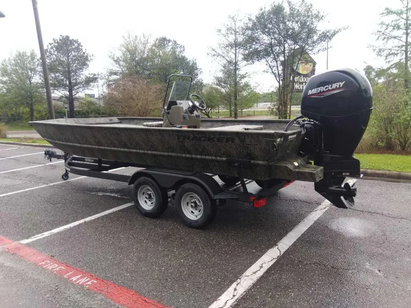 Slide: The Image of 2025 Tracker Grizzly 2072 CC boat with Mercury engine on trailer in parking lot. - 2