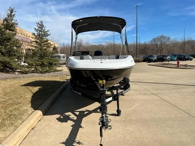 Slide: The Image of 2025 Tahoe T16 boat on trailer, parked outdoors under clear blue sky. - 2