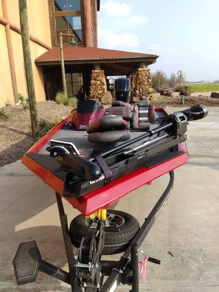 Slide: The Image of 2025 Ranger RT178 boat on trailer, parked outdoors near a building. - 2