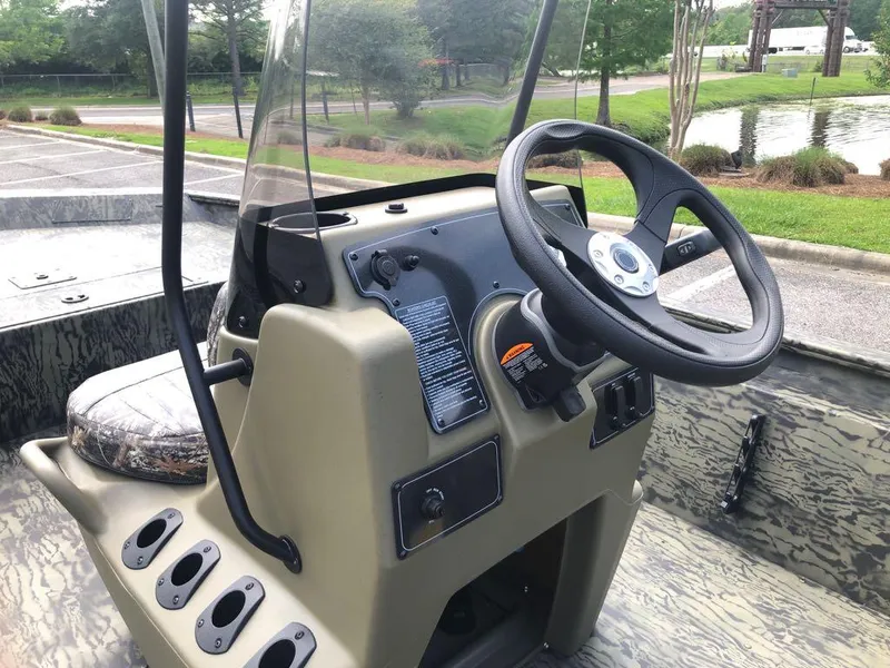 Slide: The Image of 2025 Tracker Grizzly 1860 CC boat console with steering wheel and controls. - 11