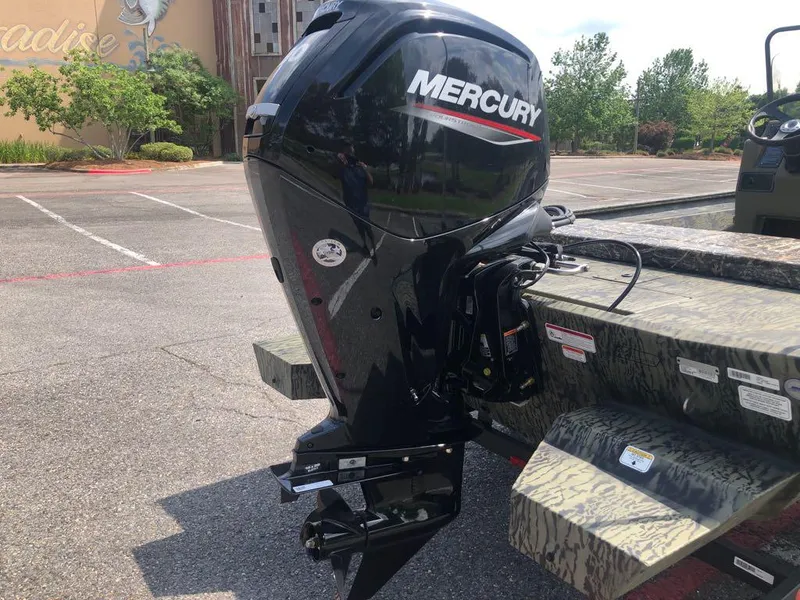 Slide: The Image of 2025 Tracker Grizzly 1860 CC with Mercury outboard motor in a parking lot. - 3