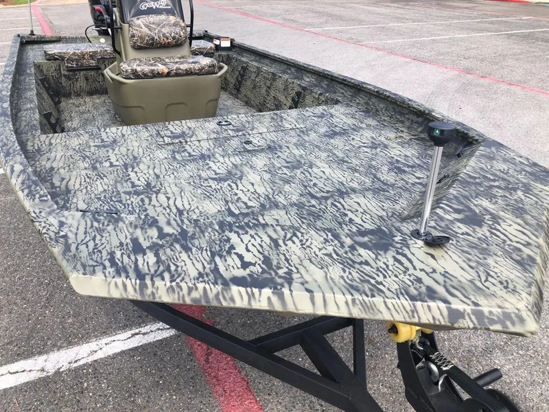 Slide: The Image of 2025 Tracker Grizzly 1860 CC boat with camouflage design on a trailer. - 8
