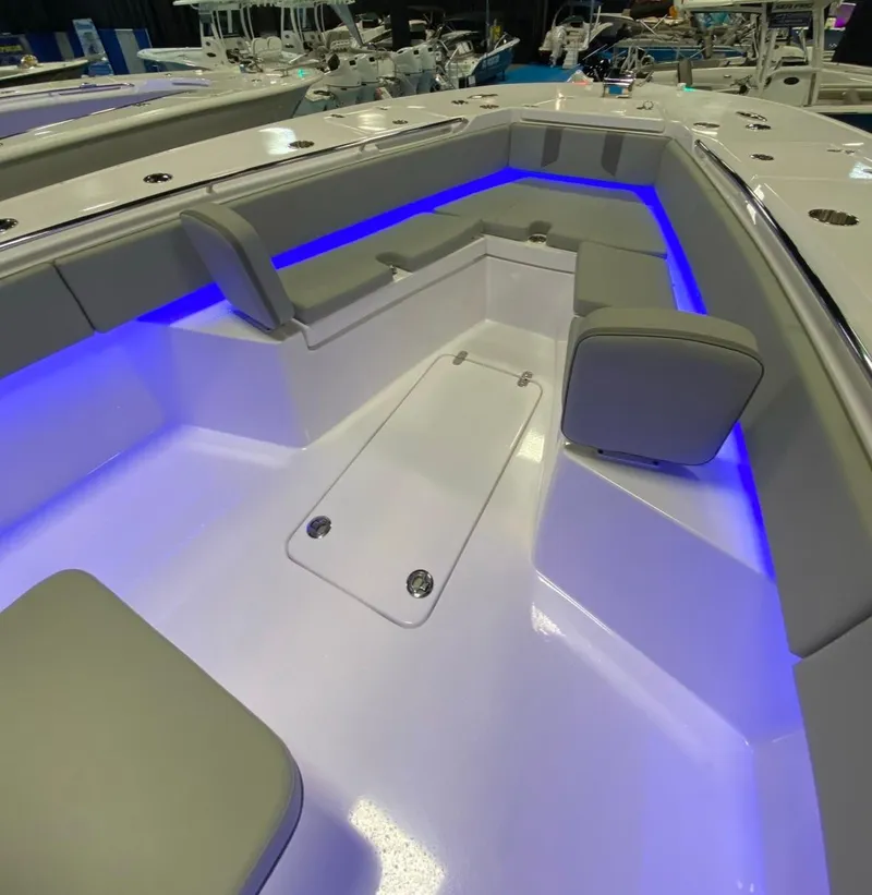 Slide: The Image of 2025 Cape Horn 34 XS boat interior with blue LED lighting and cushioned seating. - 15