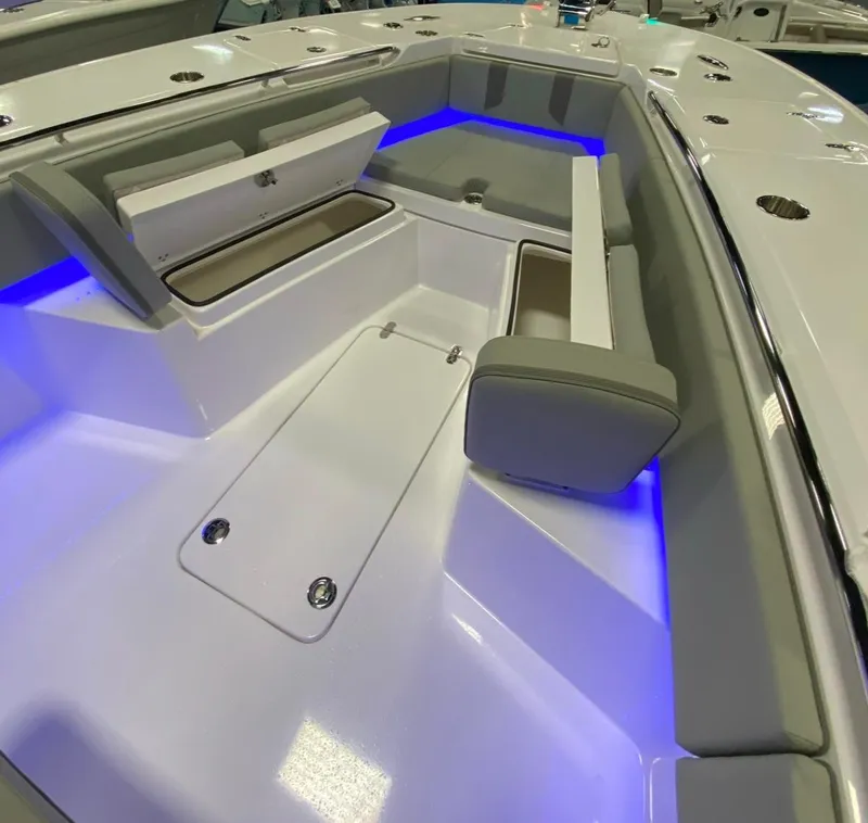 Slide: The Image of 2025 Cape Horn 34 XS boat interior with blue LED lighting and cushioned seating. - 16