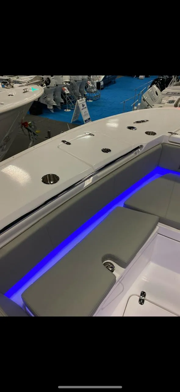 Slide: The Image of 2025 Cape Horn 34 XS boat interior with blue LED lighting and cushioned seating. - 17