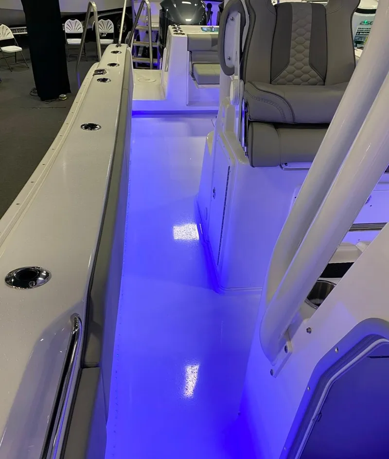 Slide: The Image of 2025 Cape Horn 34 XS boat interior with blue LED lighting and cushioned seating. - 18