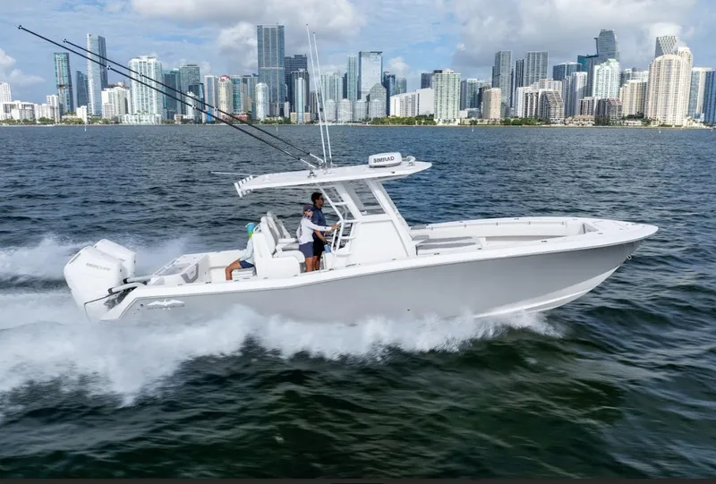 Slide: The Image of 2026 Invincible 33 Open Fisherman boat cruising near city skyline. - 1