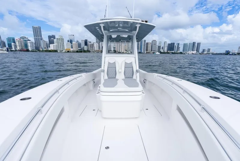 Slide: The Image of 2026 Invincible 33 Open Fisherman boat on water with city skyline backdrop. - 12