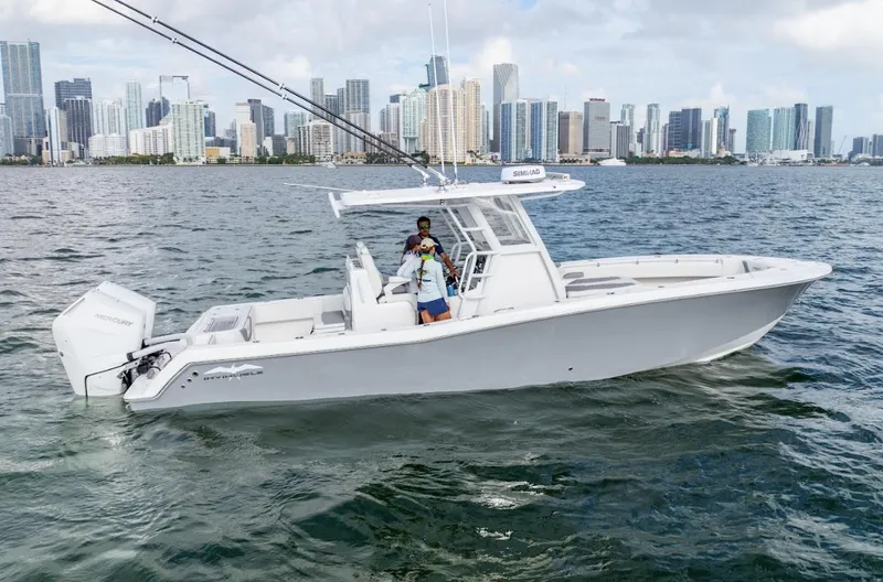 Slide: The Image of 2026 Invincible 33 Open Fisherman boat on water with city skyline in background. - 2