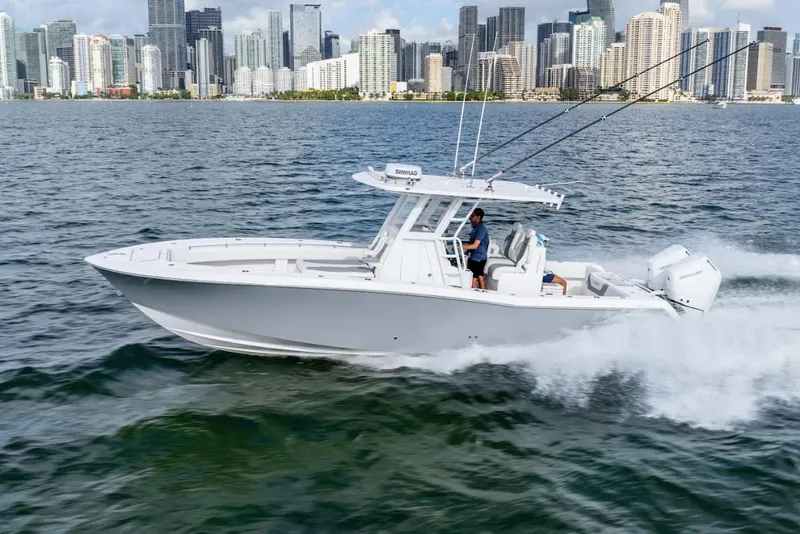 Slide: The Image of 2026 Invincible 33 Open Fisherman boat cruising near city skyline. - 5