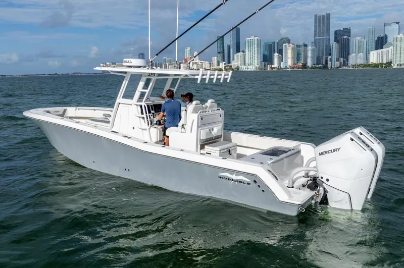 Slide: The Image of 2026 Invincible 33 Open Fisherman boat on water with city skyline in background. - 6