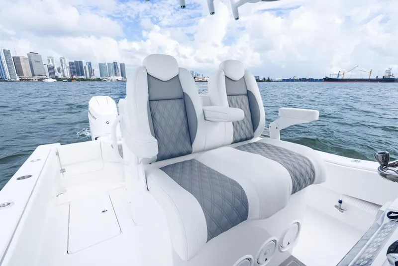 Slide: The Image of 2026 Invincible 33 Open Fisherman boat seats with city skyline in background. - 8