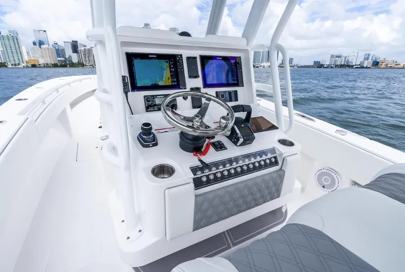 Slide: The Image of 2026 Invincible 33 Open Fisherman boat console with navigation screens on a sunny day. - 9