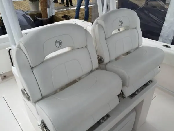 Slide: The Image of 2015 Edgewater 280CC boat with white cushioned seats on deck. - 3