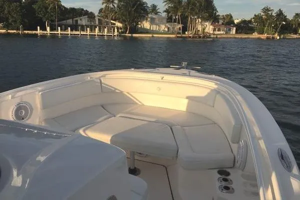 Slide: The Image of 2015 Edgewater 280CC boat with spacious seating, docked near waterfront homes. - 7