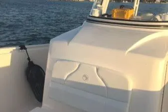 Slide: The Image of 2015 Edgewater 280CC boat on water, featuring sleek white design and spacious deck. - 8