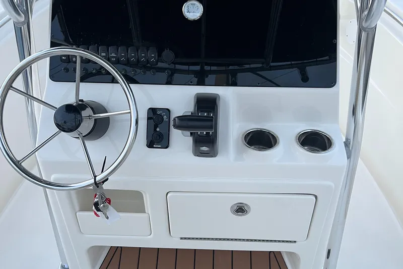 Slide: The Image of 2025 Bulls Bay 200 Center Console boat dashboard with steering wheel and controls. - 10