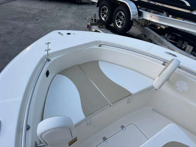 Slide: The Image of 2025 Bulls Bay 200 Center Console boat interior with cushioned seating and trailer in background. - 3